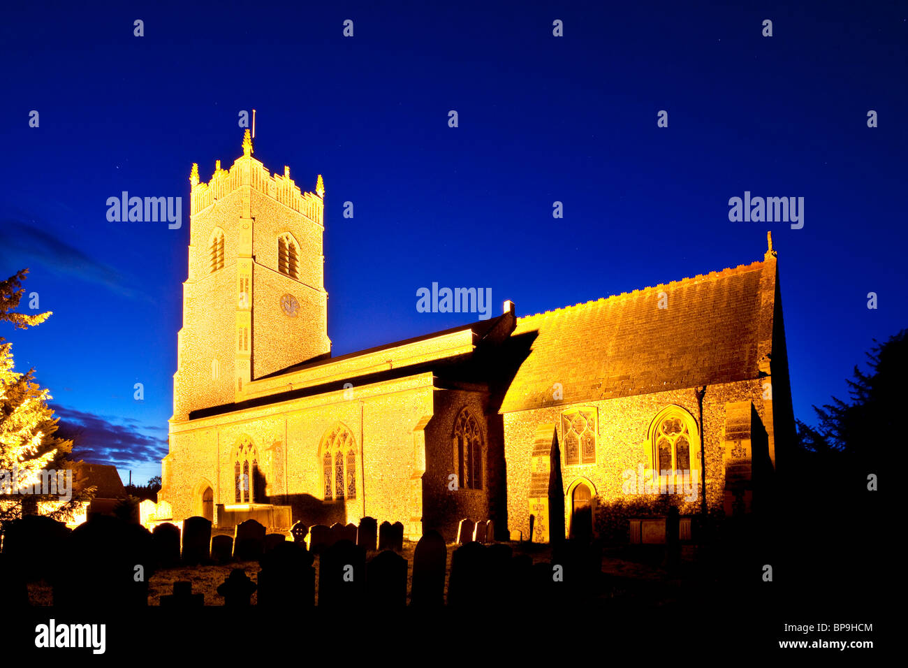 L'église Saint John's illuminée la nuit dans Garboldisham, Norfolk Banque D'Images