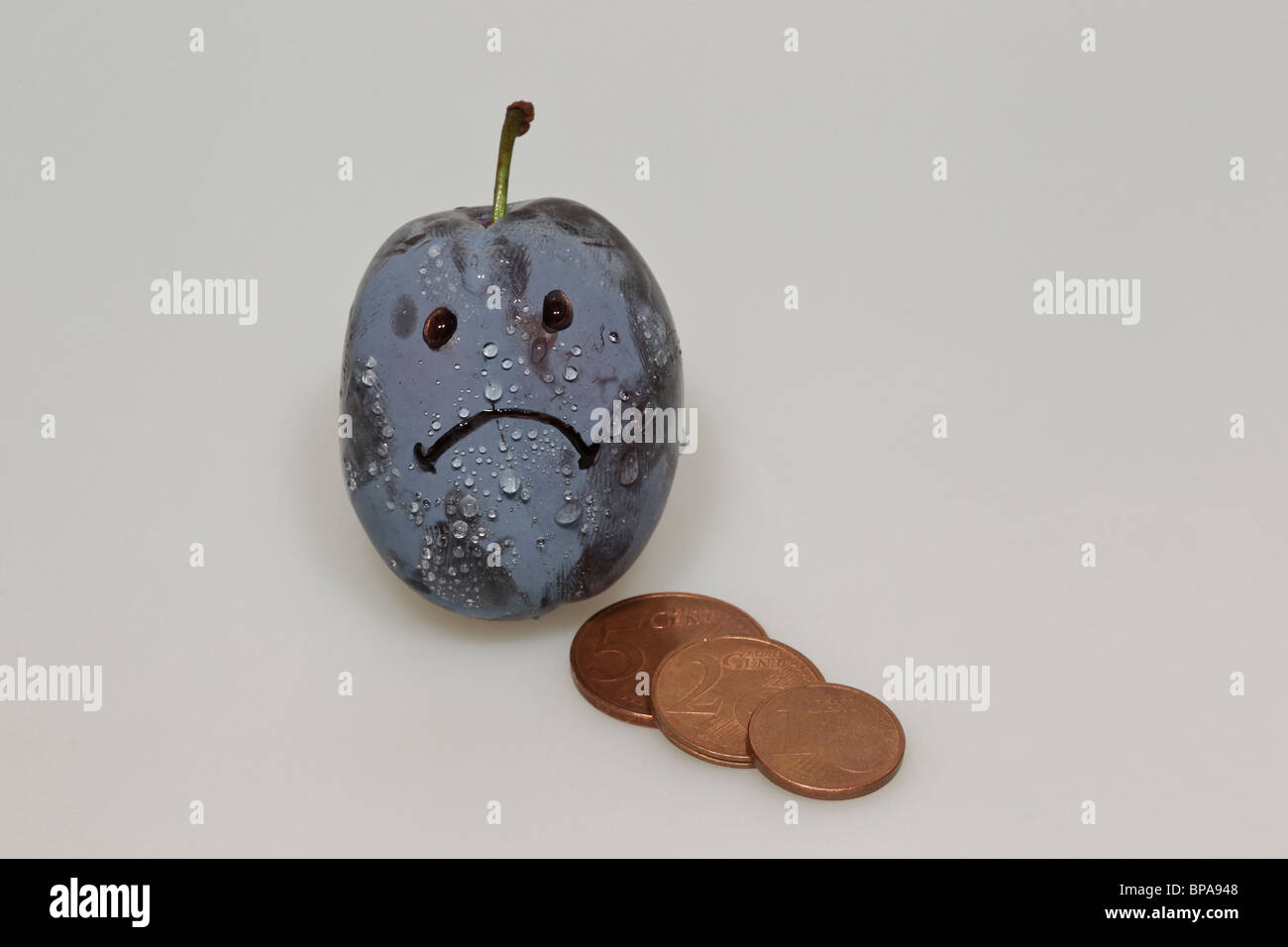 Smiley pleurer de prunes avec des gouttes d'eau et de pièces en euros Banque D'Images