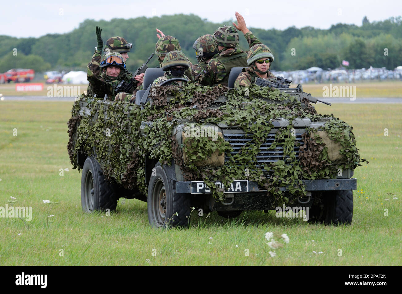 Les soldats britanniques dans leur Land Rover camouflé quitter la zone d'affichage à l'édition 2010 du Royal International Air Tattoo RIAT Banque D'Images