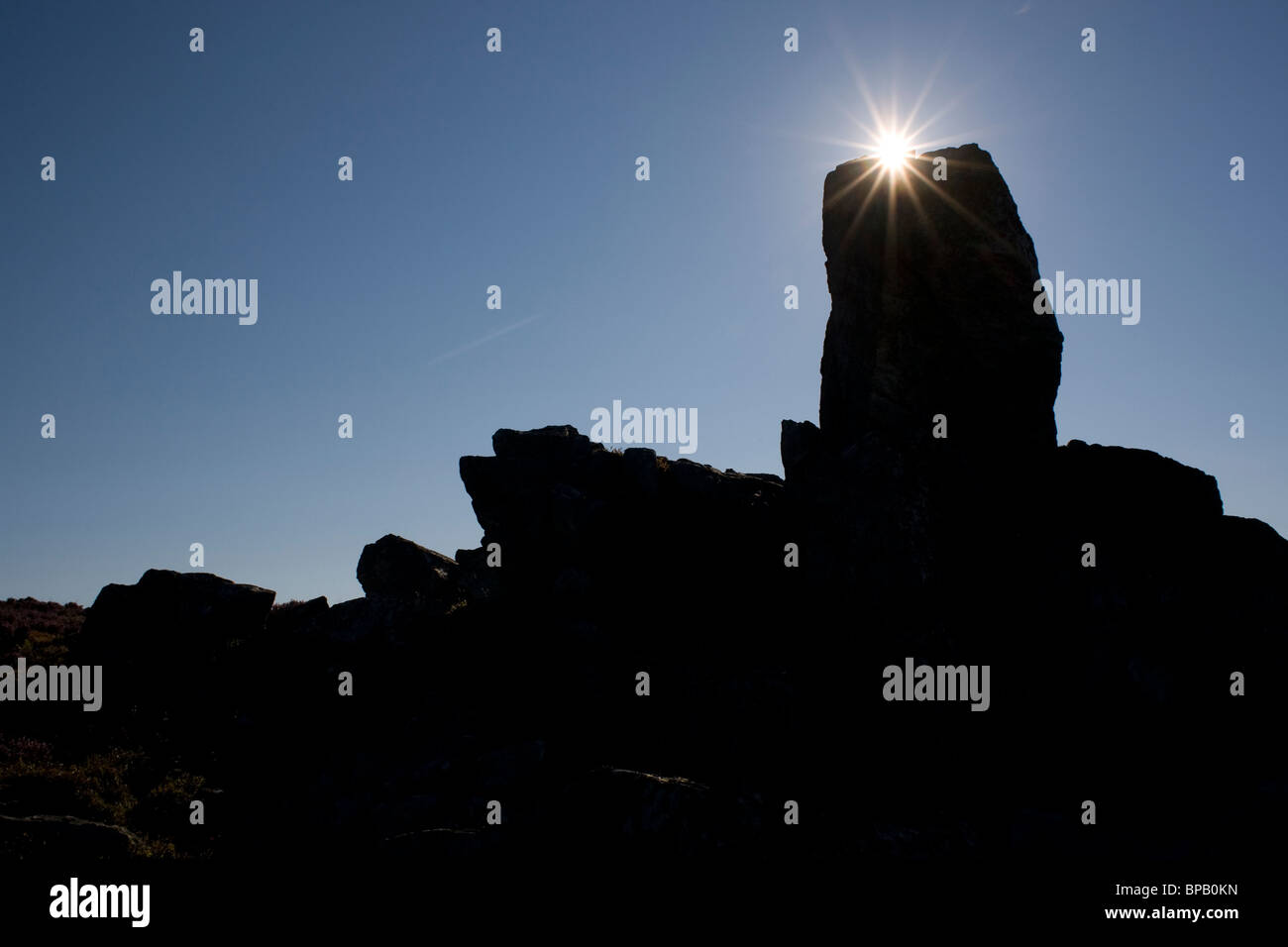 Le Shropshire : paysage de la silhouette spectaculaire Stiperstones avec le soleil produisant un effet d'étoile qu'il s'élève au-dessus des rochers. Banque D'Images