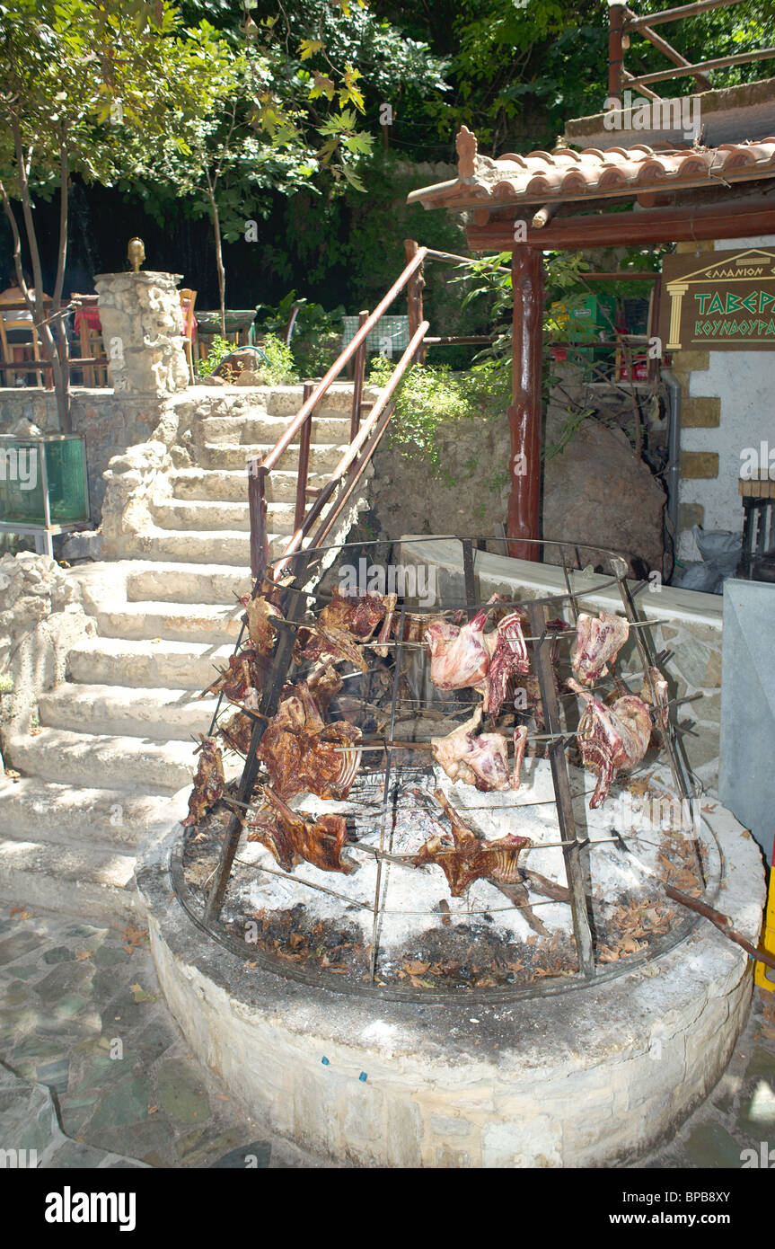 La cuisson de la viande sur feu ouvert barbecue à l'extérieur d'une taverna Crète Grèce Banque D'Images
