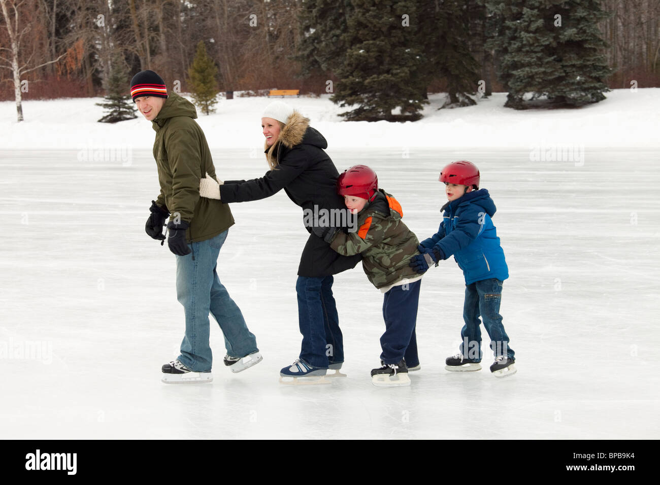Edmonton, Alberta, Canada ; une famille patiner sur une patinoire en plein air Banque D'Images