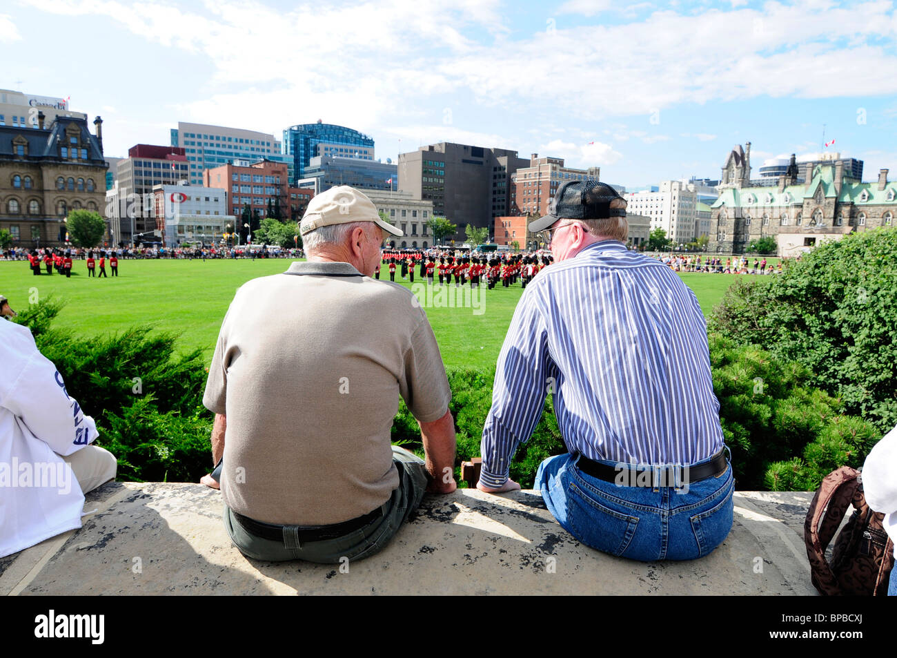 Deux hommes regardant la cérémonie de Relève de la garde sur la Colline du Parlement Ottawa Canada Banque D'Images