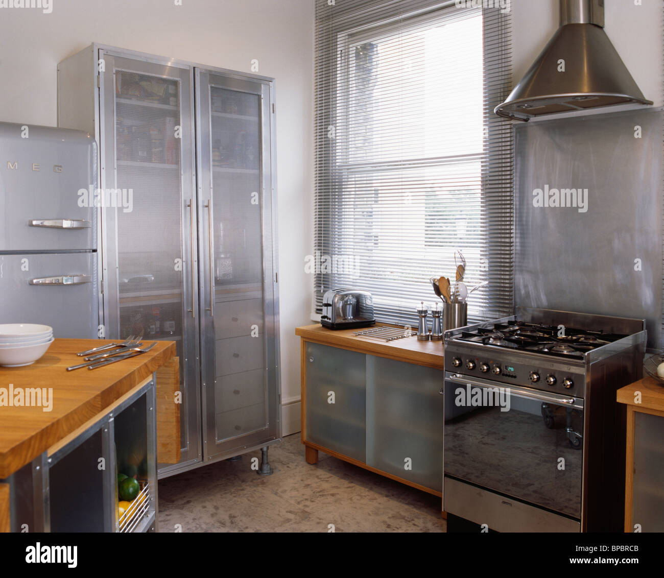 Grand métal armoire avec portes en verre opaque dans une cuisine moderne  avec cuisinière four Photo Stock - Alamy