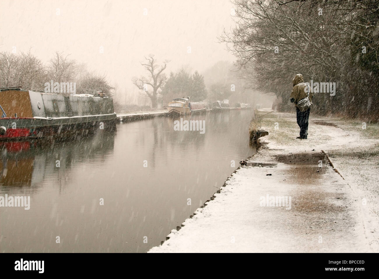 Pêche au leurre sur le canal de Coventry dans la neige. Banque D'Images