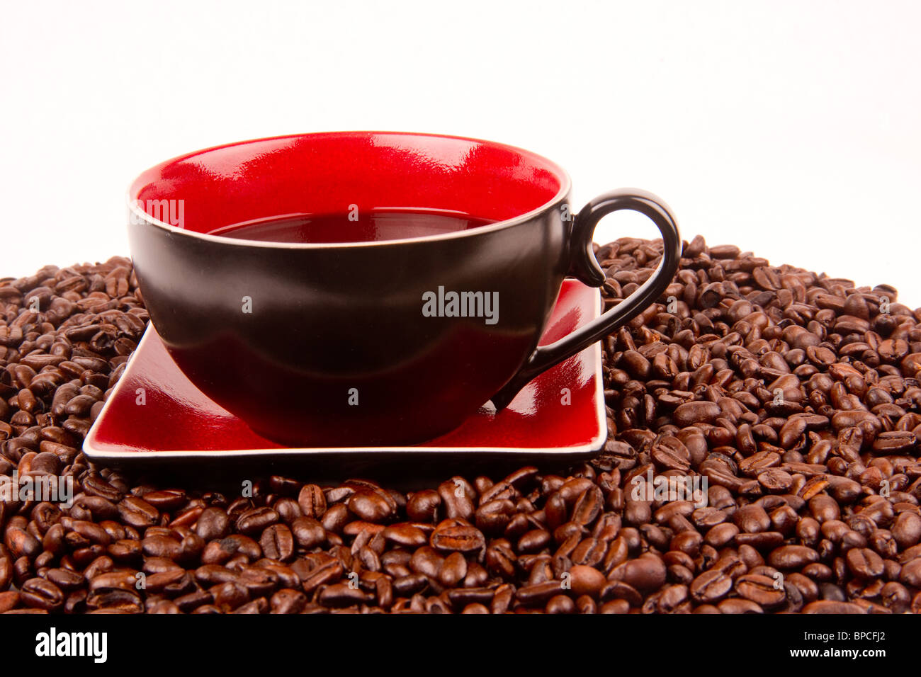 Tasse et soucoupe à café assis dans un tas de grains de café Banque D'Images