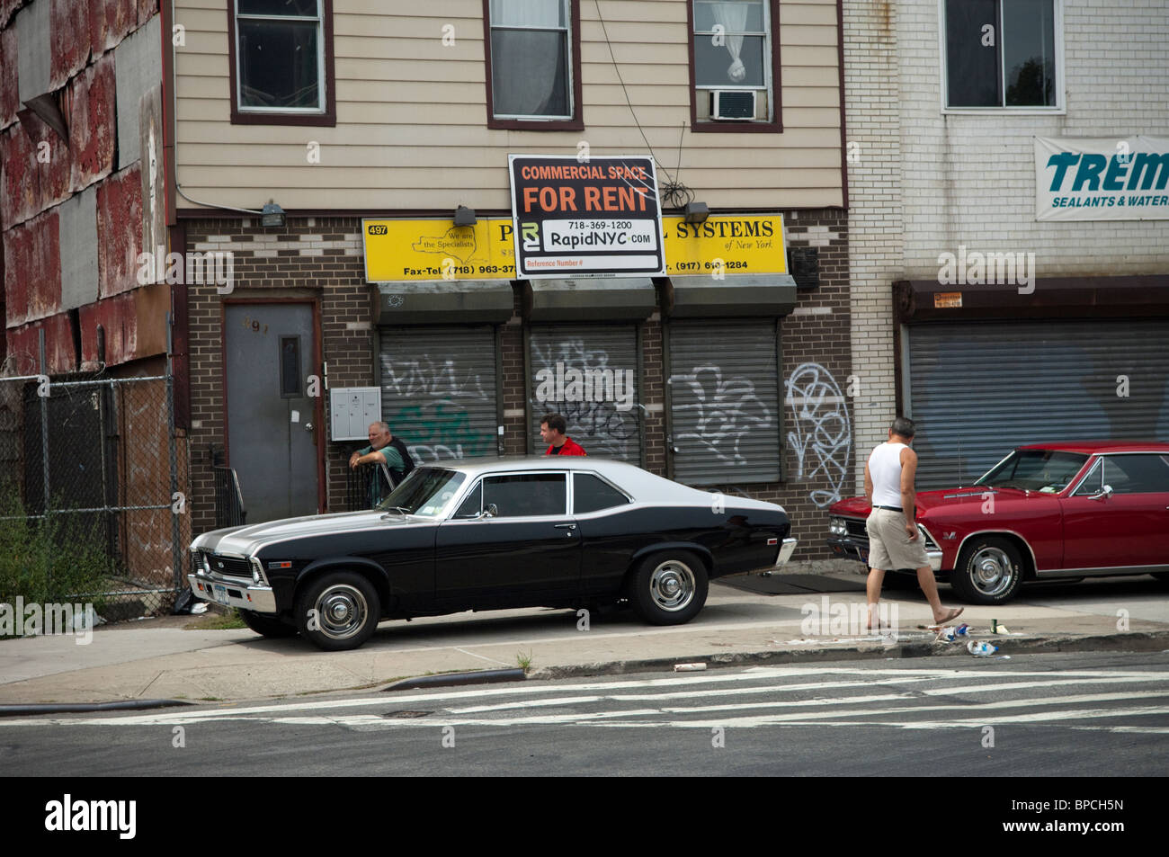 Voiture sur mesure et les amateurs de hot rod garent leur voiture devant un magasin à louer dans le quartier de Williamsburg, New York Banque D'Images