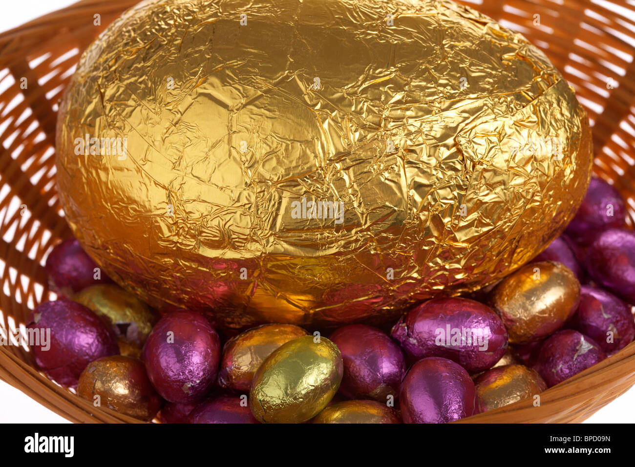 Grandes et petites dorure chocolat oeufs de Pâques dans un panier Banque D'Images