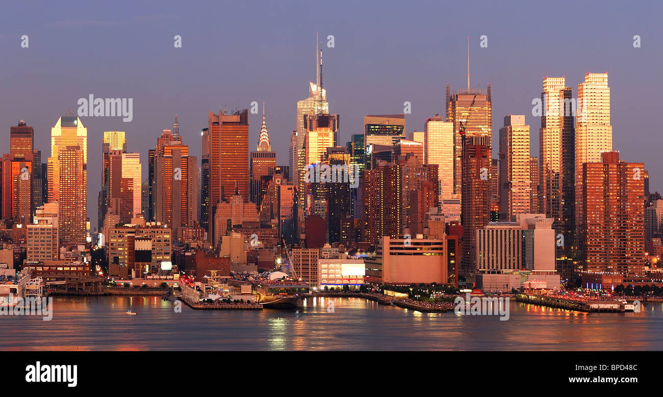 New York City Manhattan skyline panorama au coucher du soleil avec Times Square et gratte-ciel avec la réflexion sur le fleuve Hudson. Banque D'Images