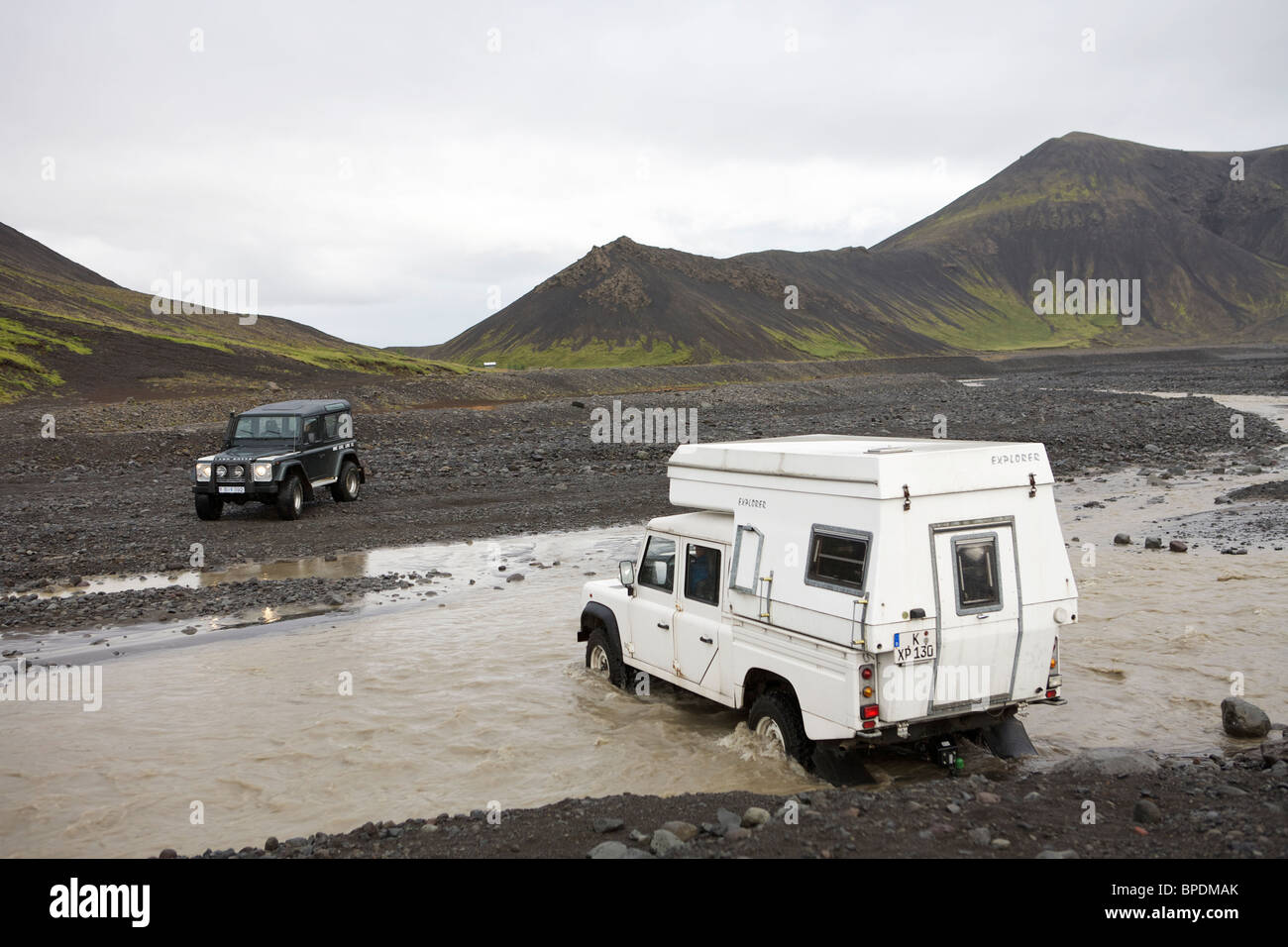 Land Rover 2 une rivière à gué dans l'intérieur hautes terres d'Islande. Defender 90 et un Defender 130 avec un camping-car Banque D'Images