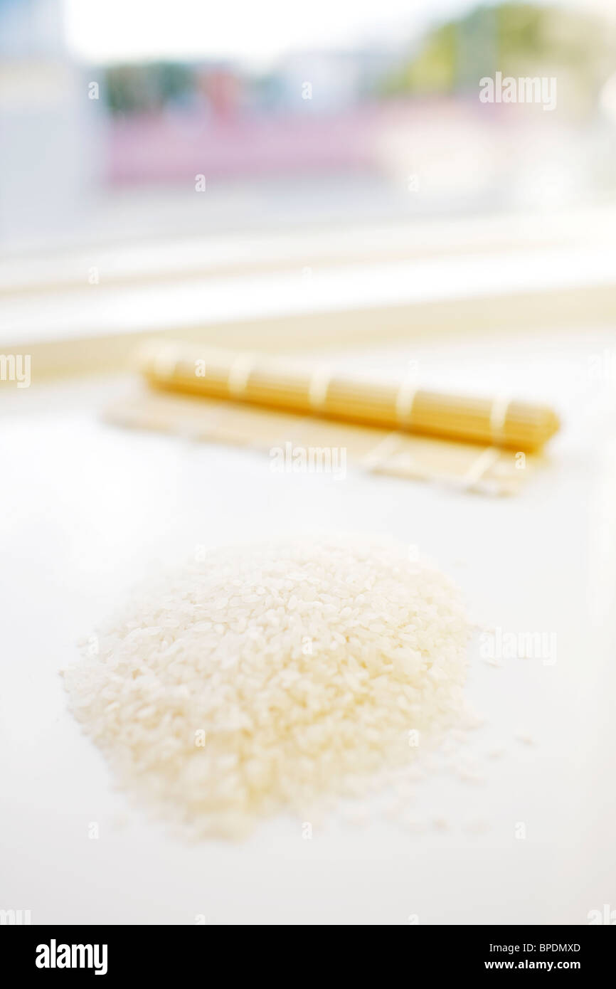 Riz à sushi avec un sushi mat à l'arrière-plan Banque D'Images