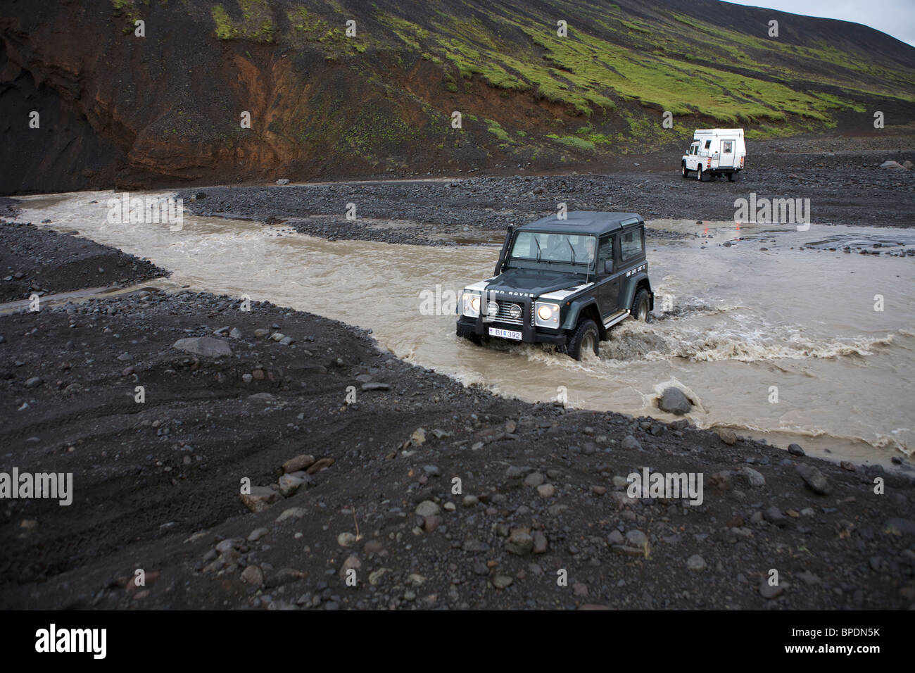 Land Rover 2 une rivière à gué dans l'intérieur hautes terres d'Islande. Defender 90 et un Defender 130 avec un camping-car Banque D'Images