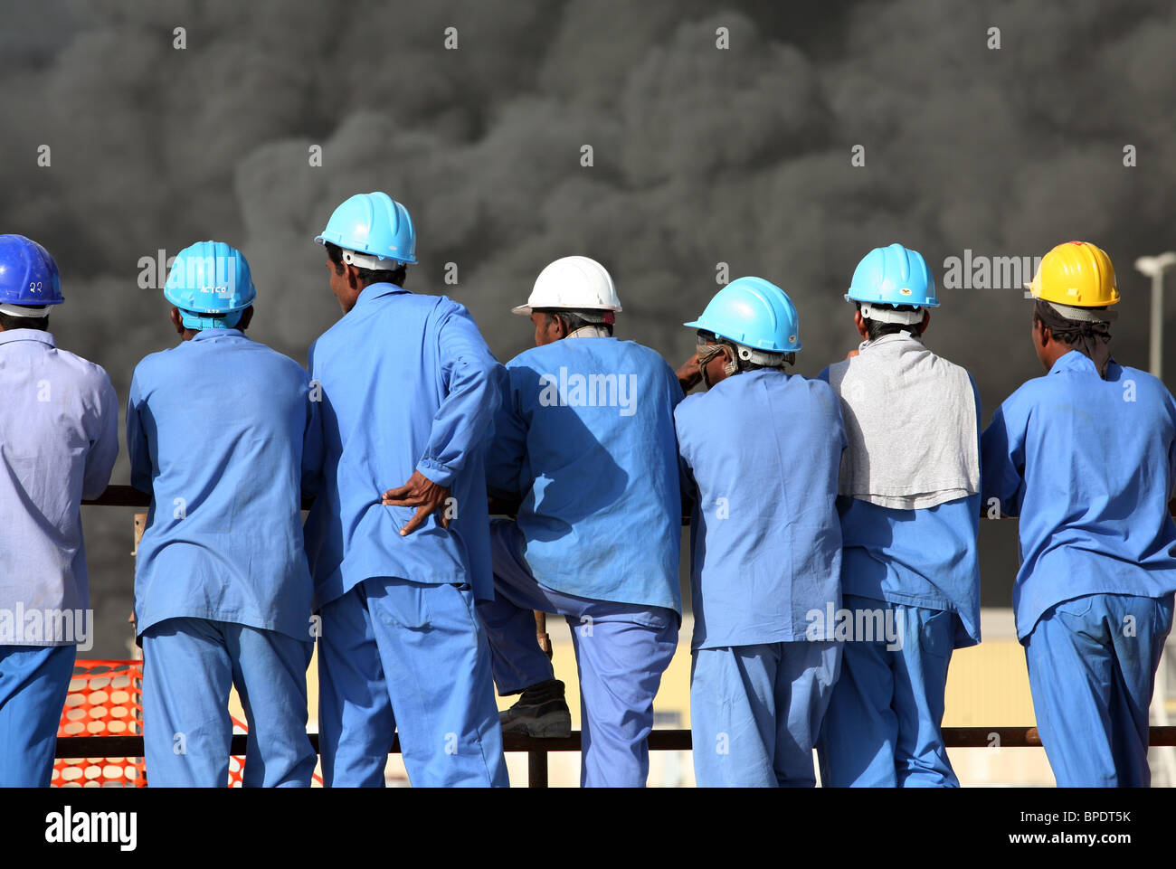 Les travailleurs de la construction à la recherche d'un sombre nuage de fumée, Dubai, Émirats Arabes Unis Banque D'Images