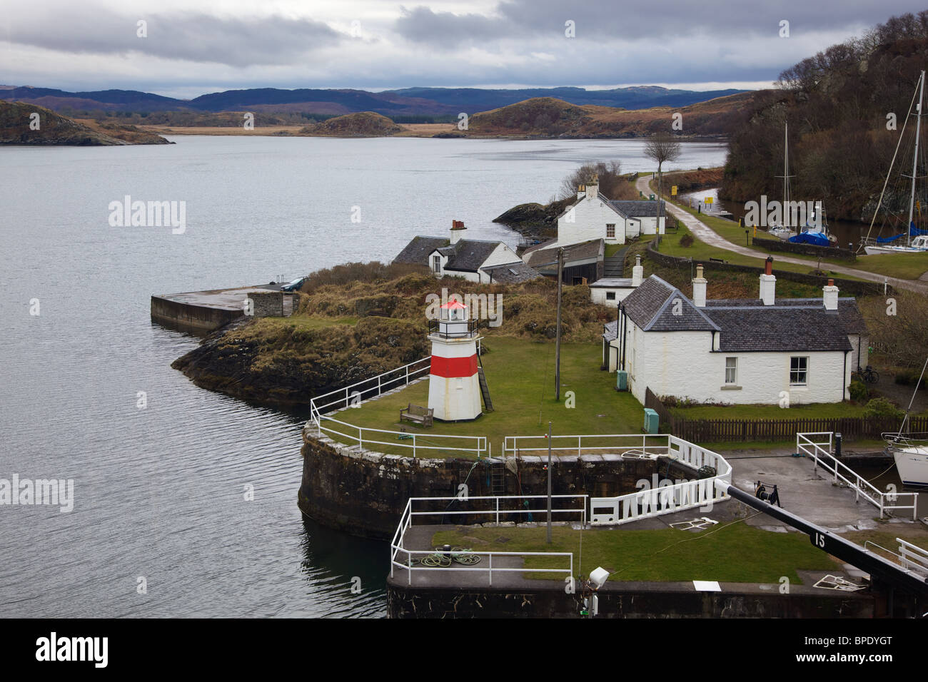 Blocage de la mer et le phare marquant le point où le canal Crinan rejoint le son du Jura Banque D'Images