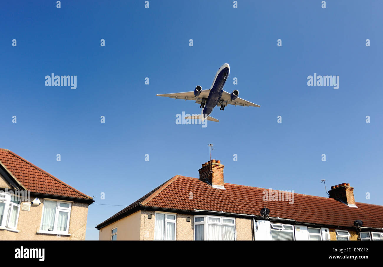 British Airways avion volant à basse altitude au-dessus house avant l'atterrissage Banque D'Images