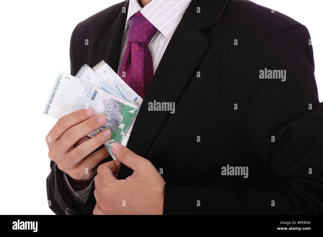 Un homme tirant sur l'argent comptant hors de sa veste Banque D'Images