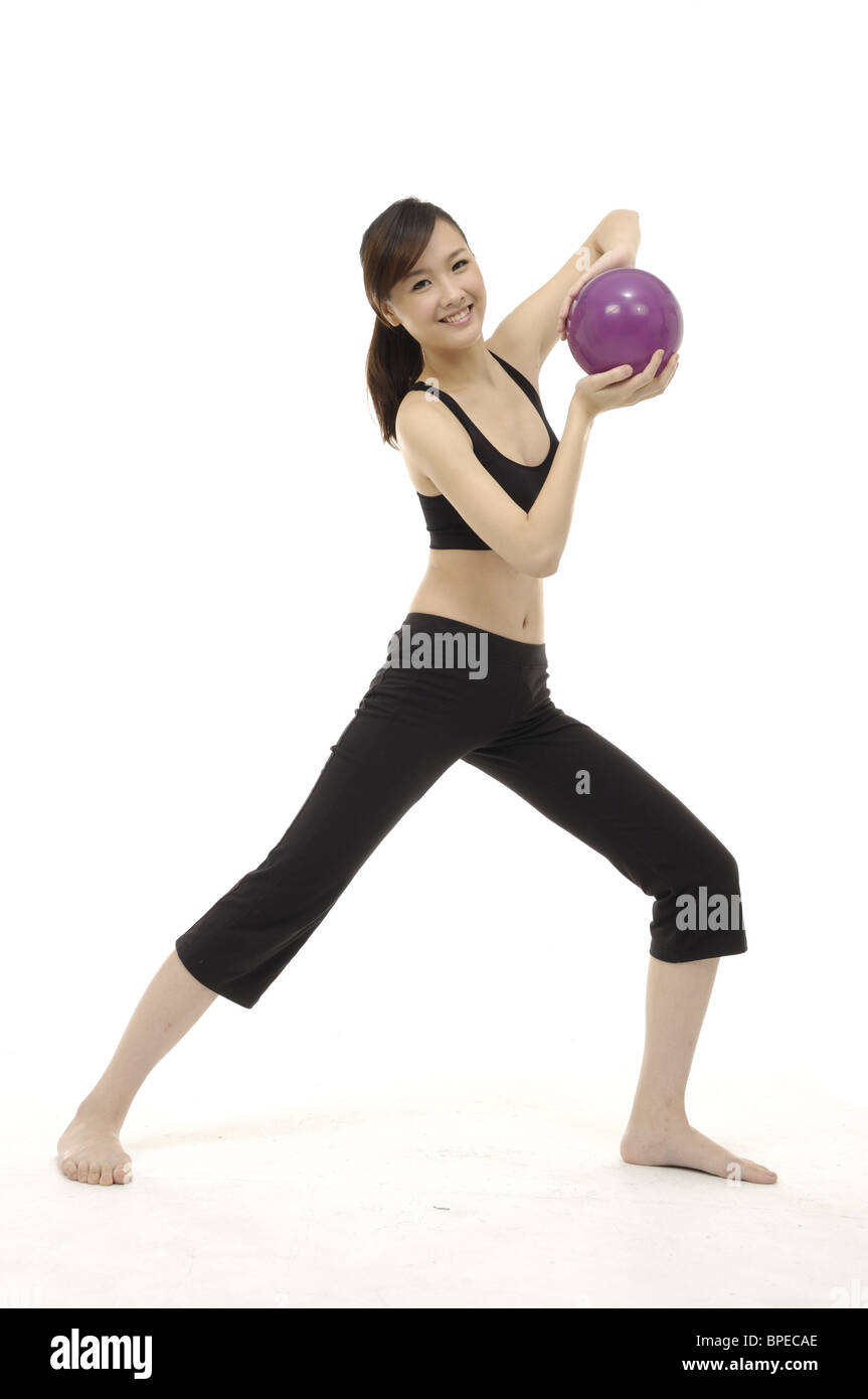 Young woman doing stretching exercise fitness ball Banque D'Images