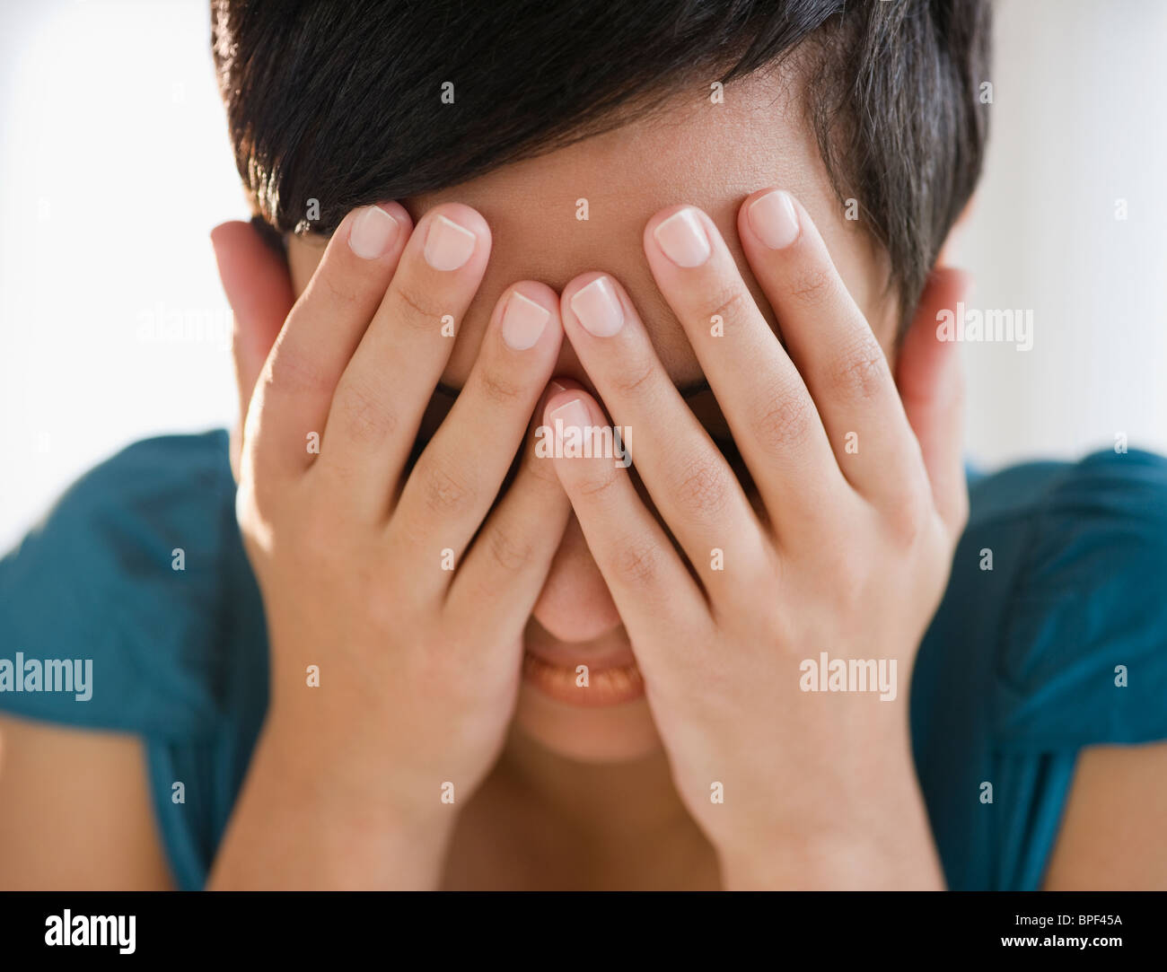 Mixed Race woman covering face with hands Banque D'Images