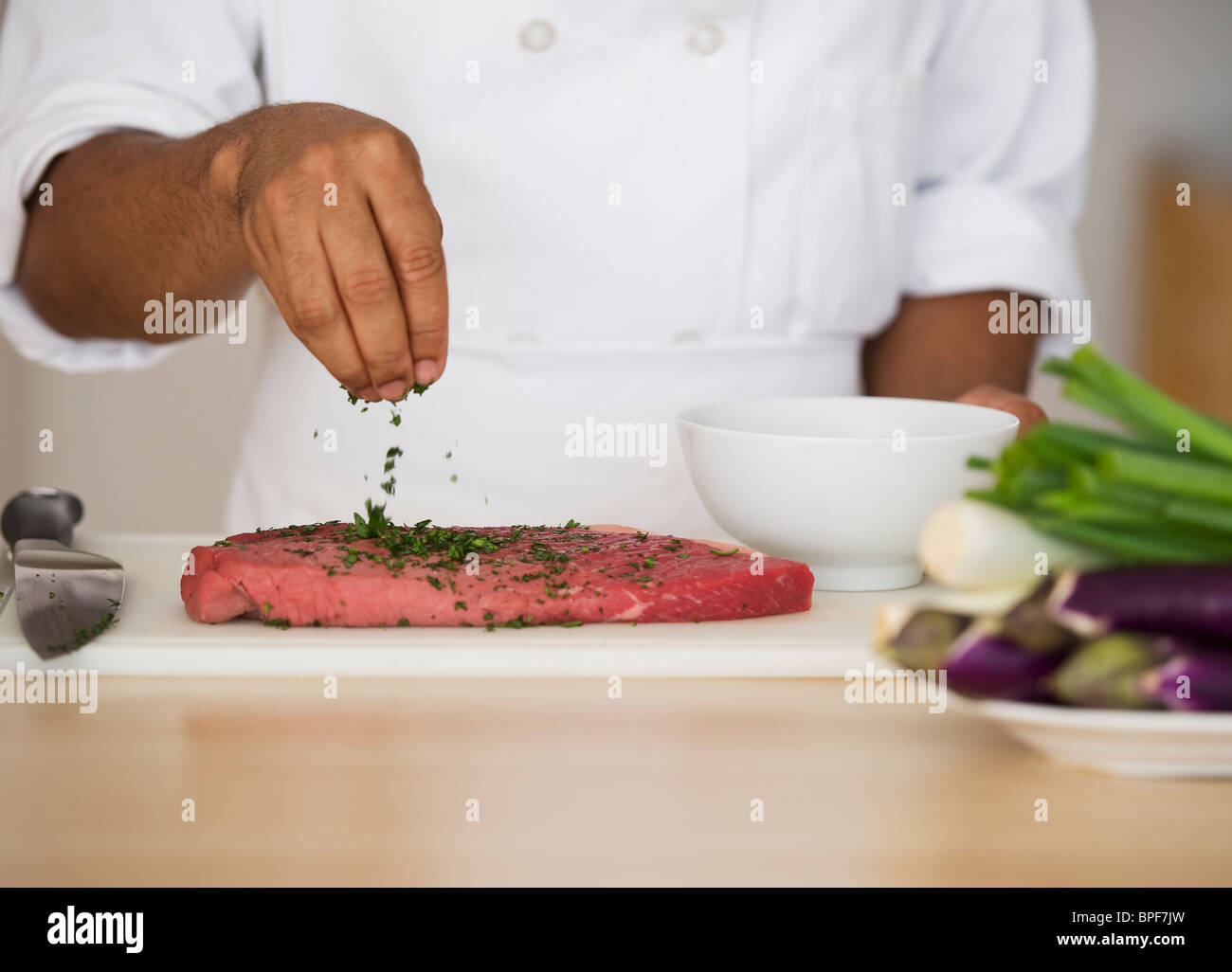 Mixed Race chef steak assaisonnement Banque D'Images