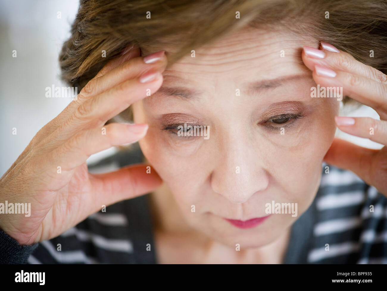 Triste Japanese woman with head in hands Banque D'Images