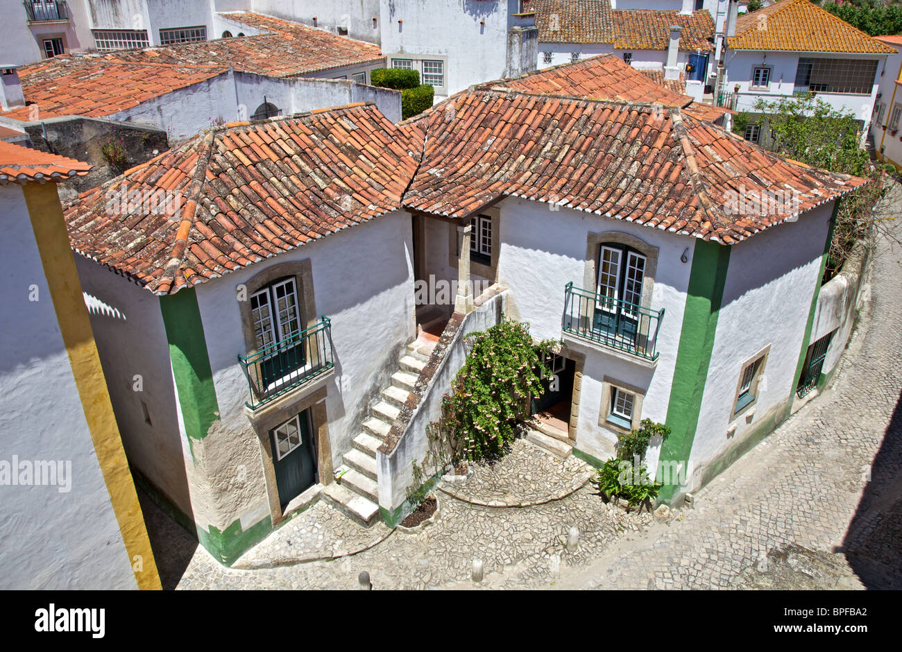 Villa blanchie à la chaux avec un toit en terre cuite dans les remparts du village médiéval d'Obidos, Portugal Banque D'Images