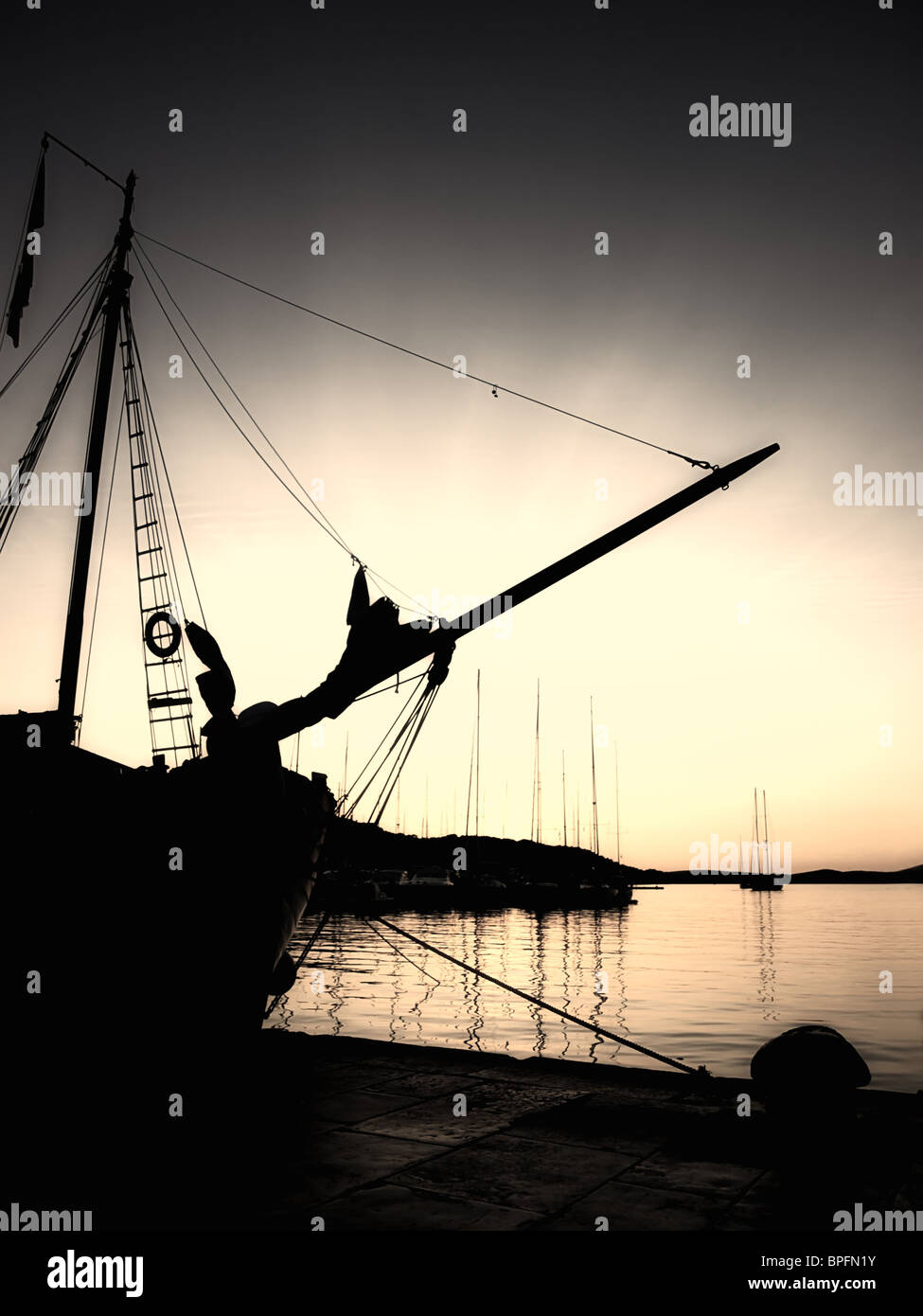 Image sépia et silhouette d'un vieux bateau dans le port de l'Adriatique dans le quartier calme et paisible soirée. Banque D'Images