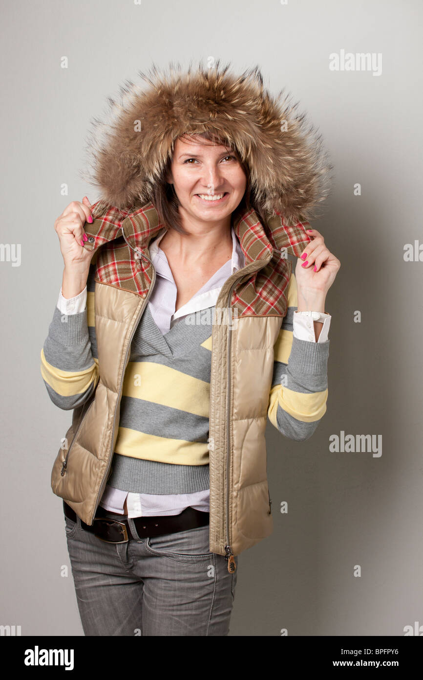 Femme souriante en tenue d'hiver avec capuche doublée de fourrure Banque D'Images