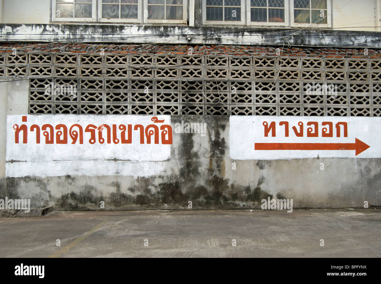 Signe de langue thaï dans un parking à phetchabun, Thaïlande, Asie du Sud-Est, en indiquant 'car park' (gauche) et 'way out' (droite) Banque D'Images