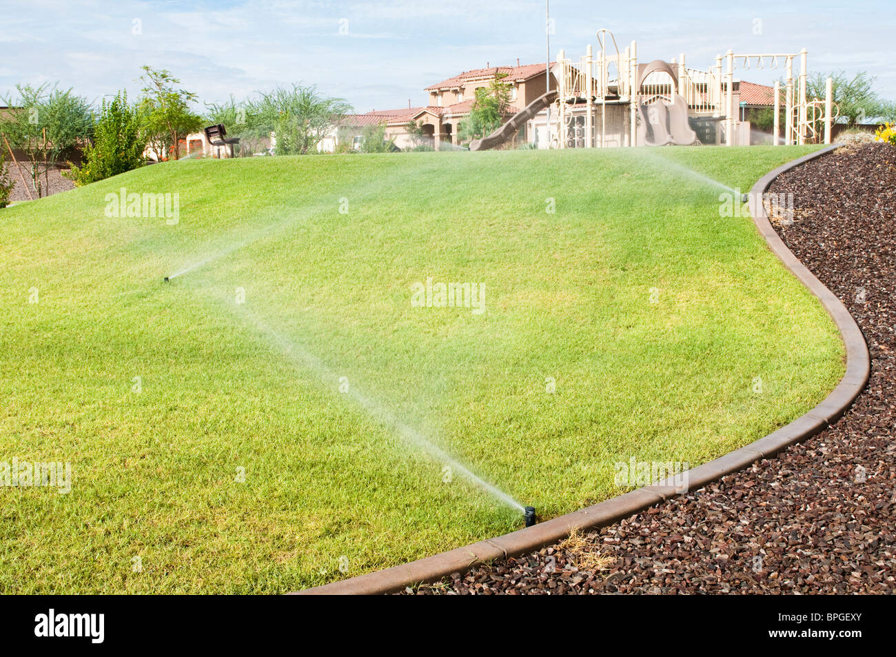 Un arrosage automatique est utilisé pour l'eau l'herbe dans un parc de la ville de l'Arizona. Banque D'Images