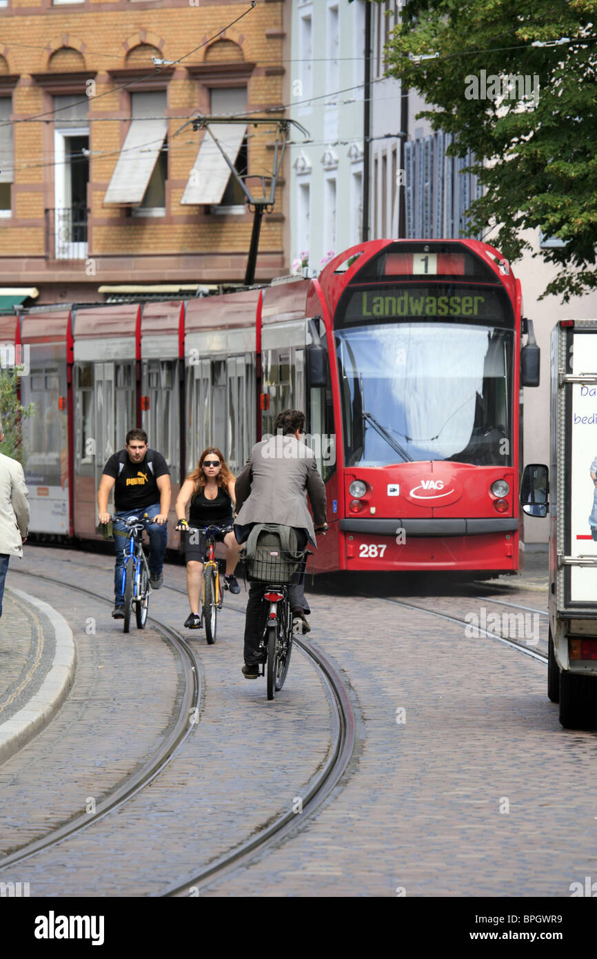 Le tramway électrique VAG et les cyclistes à Freiburg im Breisgau, Baden Wurtemberg, Allemagne Banque D'Images