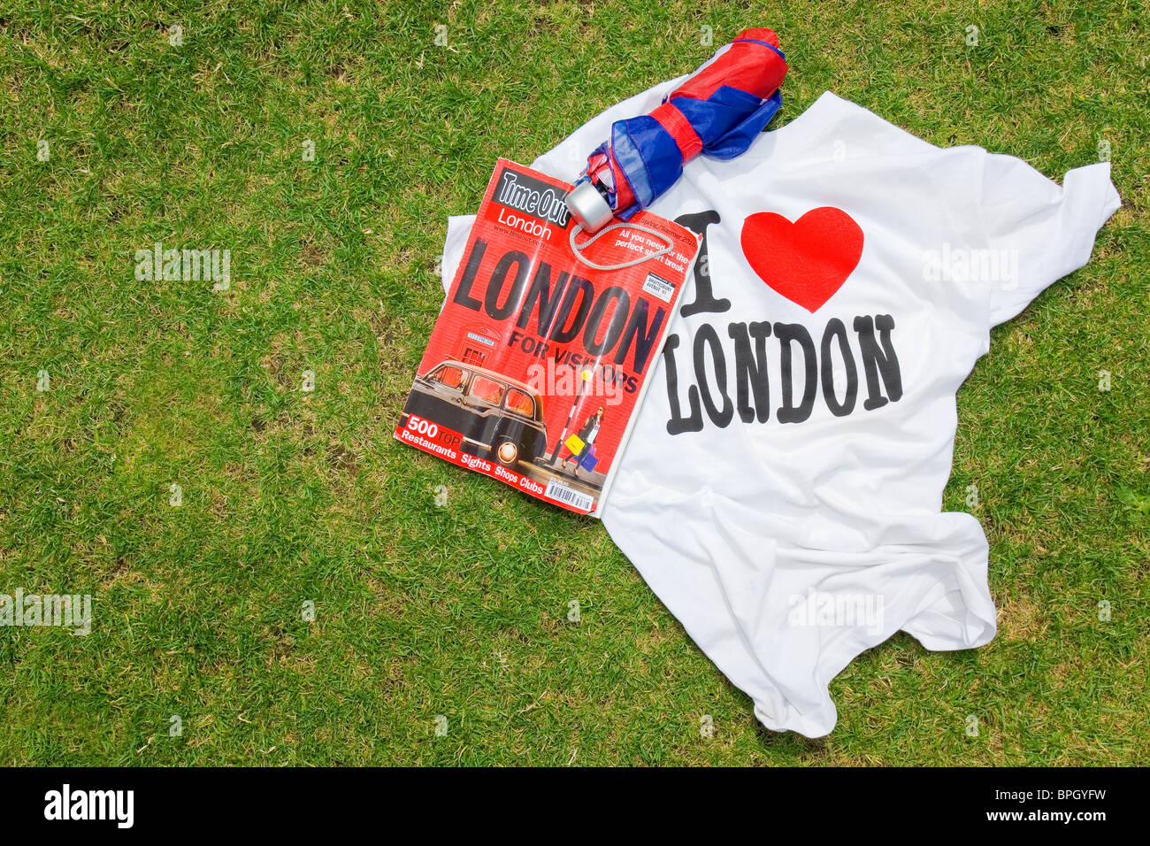 London still life with Union Jack parapluie, j'aime London T-shirt et une copie d'un magazine de Londres. Banque D'Images