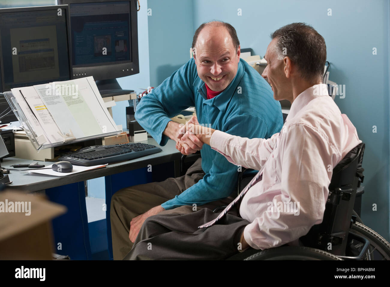 Deux businessmen shaking hands in office, l'un avec l'Ataxie de Friedreich et un autre avec de la moelle épinière Banque D'Images