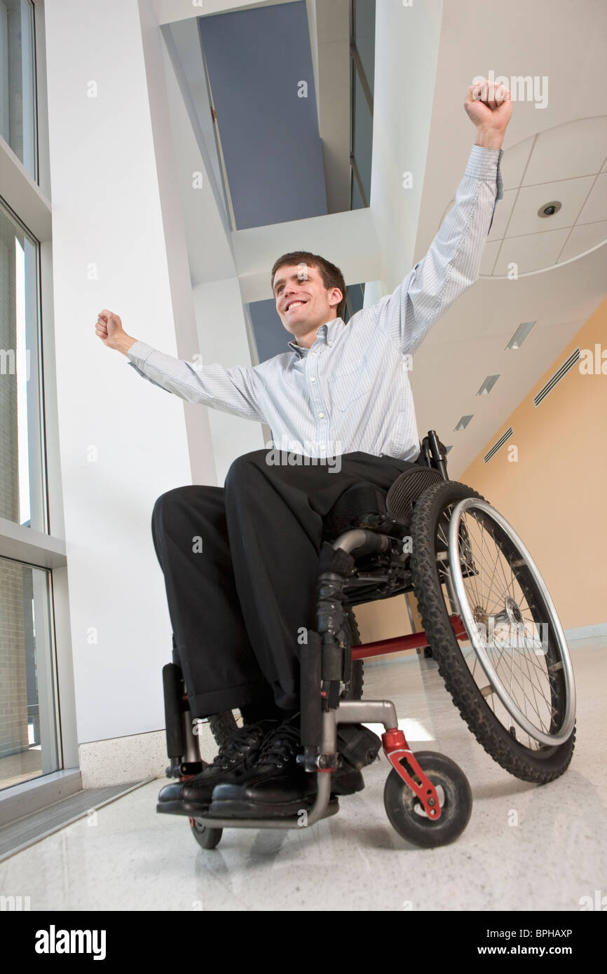 Businessman avec de la moelle épinière dans un fauteuil roulant à la hâte Banque D'Images