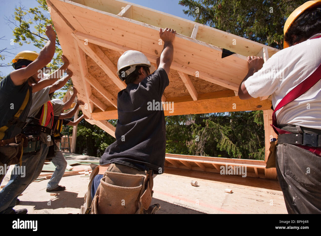 Les charpentiers de toiture châssis gable de levage sur un chantier de construction Banque D'Images