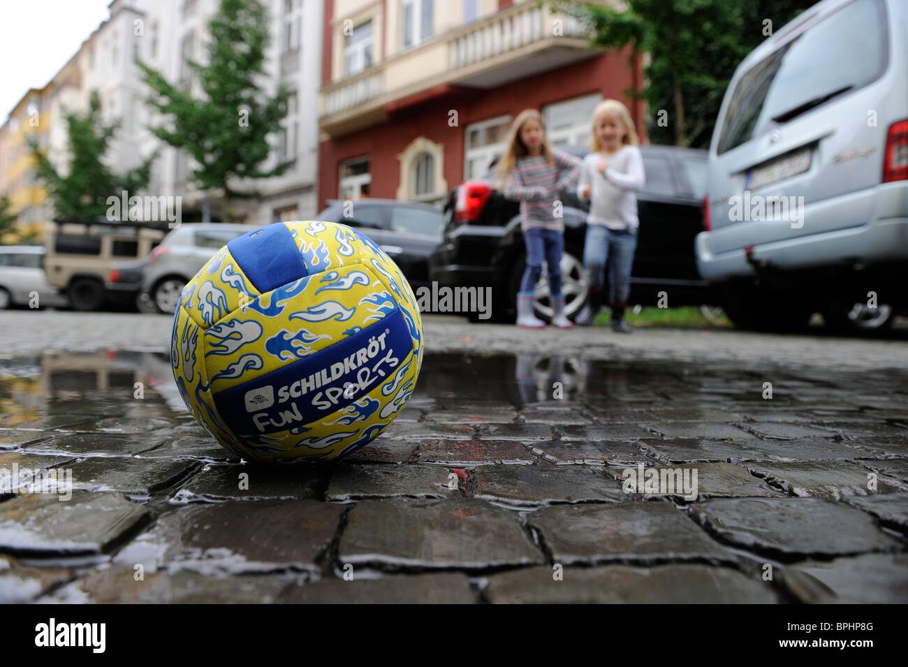 Deux jeunes filles, jouant avec une balle dans la ville. Banque D'Images