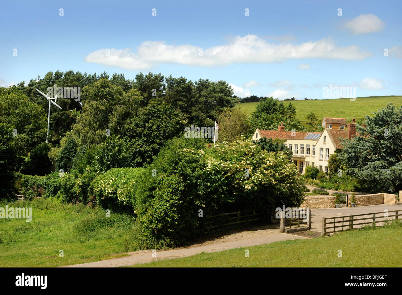 Une éolienne dans le jardin d'une maison familiale avec des panneaux solaires sur le toit dans le Buckinghamshire UK Banque D'Images