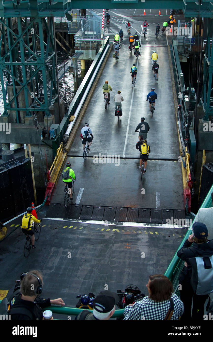 Seattle les navetteurs cyclistes quittent le ferry tôt le matin comme marcher sur les passagers regarder et attendre leur tour pour débarquer. Banque D'Images