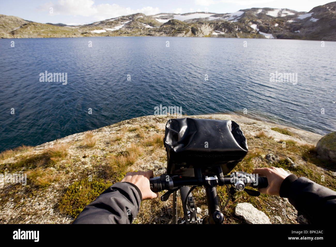 Cycliste à un lac sur le Rallarvegen à la fin de l'été, parc national de Hardangervidda, Hordaland, au sud de la Norvège, Scandinavie, Euro Banque D'Images