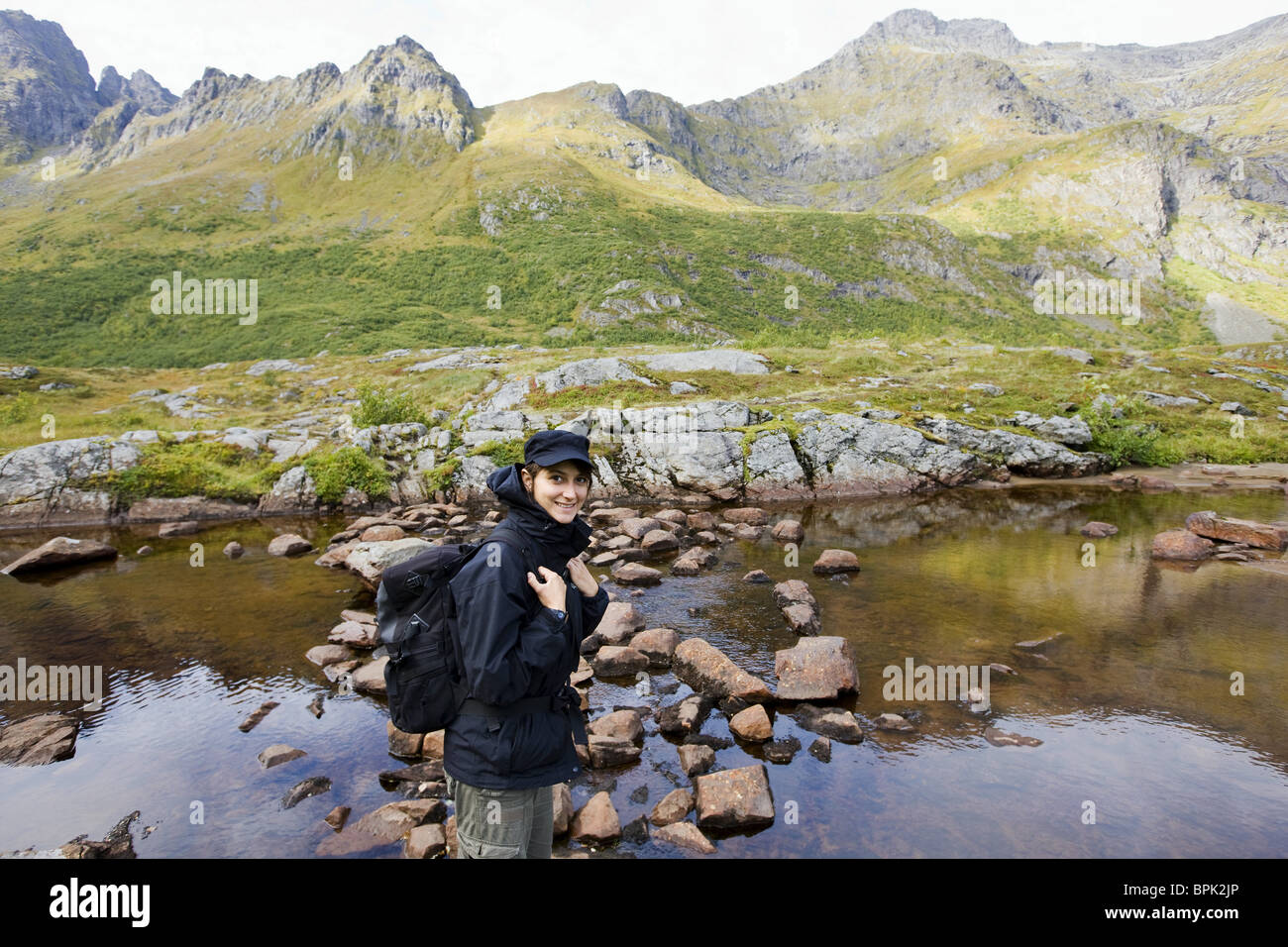 Jeune femme de la rive d'un lac dans les montagnes, Lofoten, Norway, Scandinavia, Europe Banque D'Images