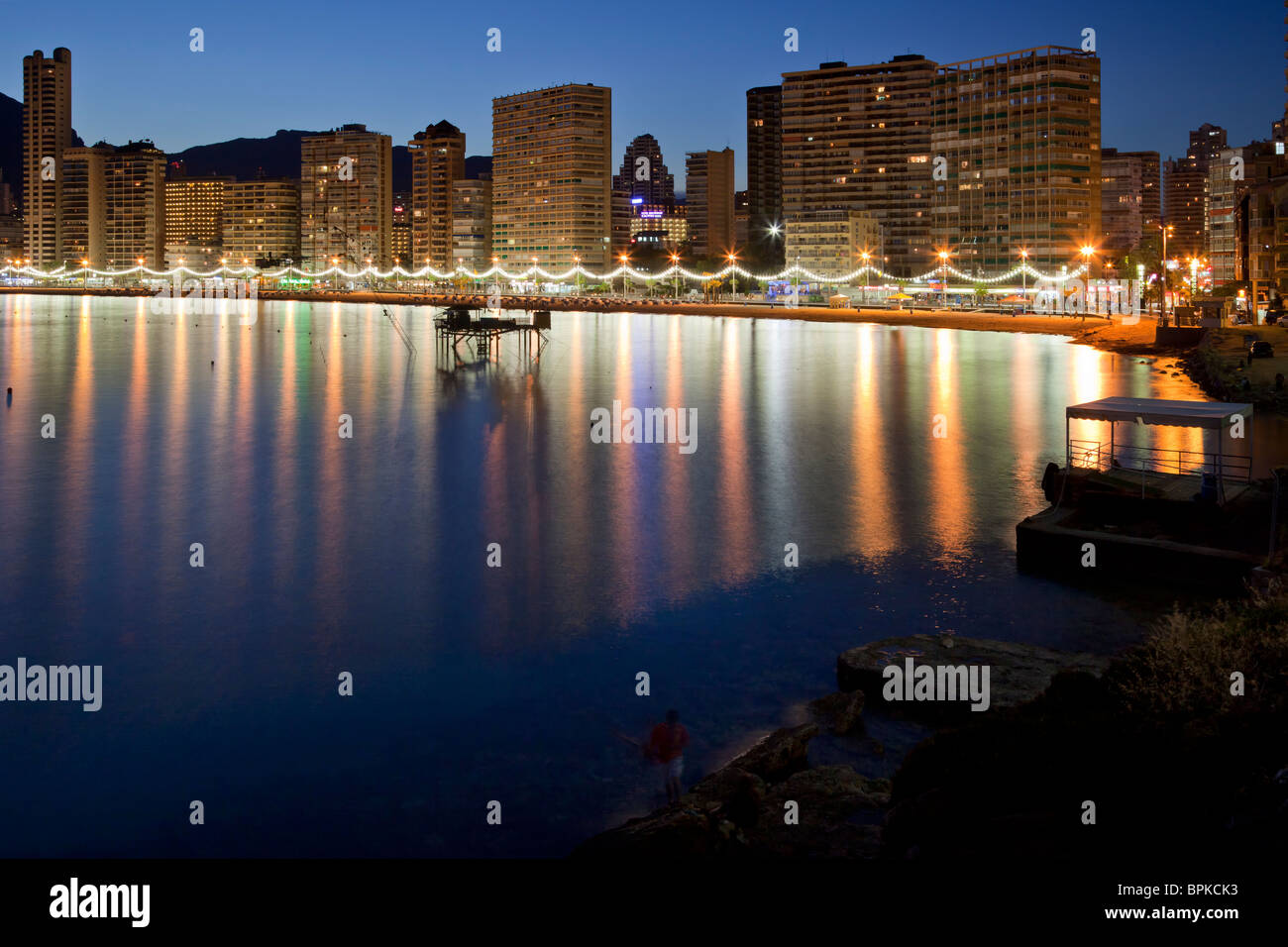 L'attrayante Benidorm Levante Beach north end corner au crépuscule, avec ses bâtiments et courts de promenade se reflétant dans la mer. Banque D'Images