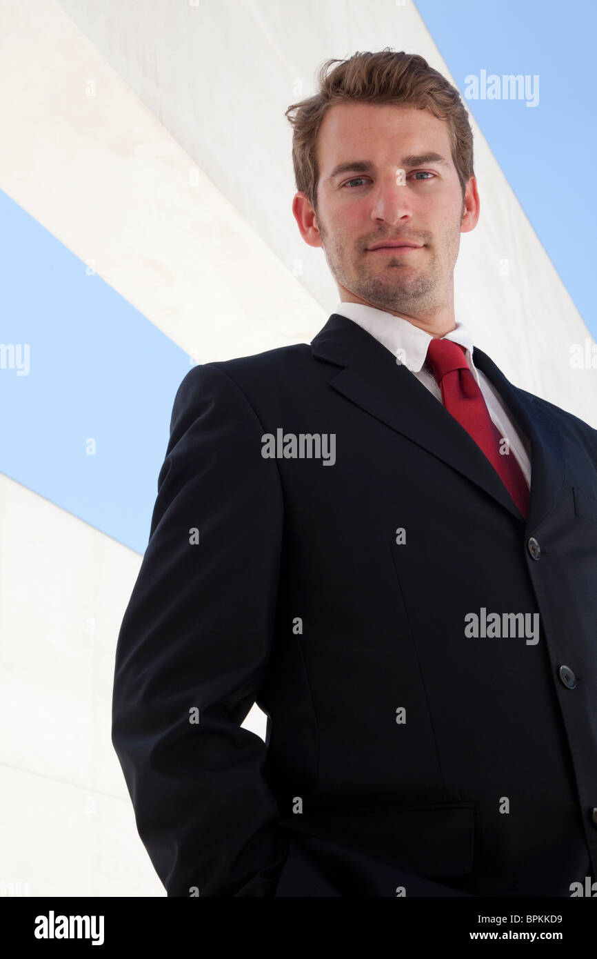Jeune homme d'affaires contre un immeuble moderne et du ciel Banque D'Images