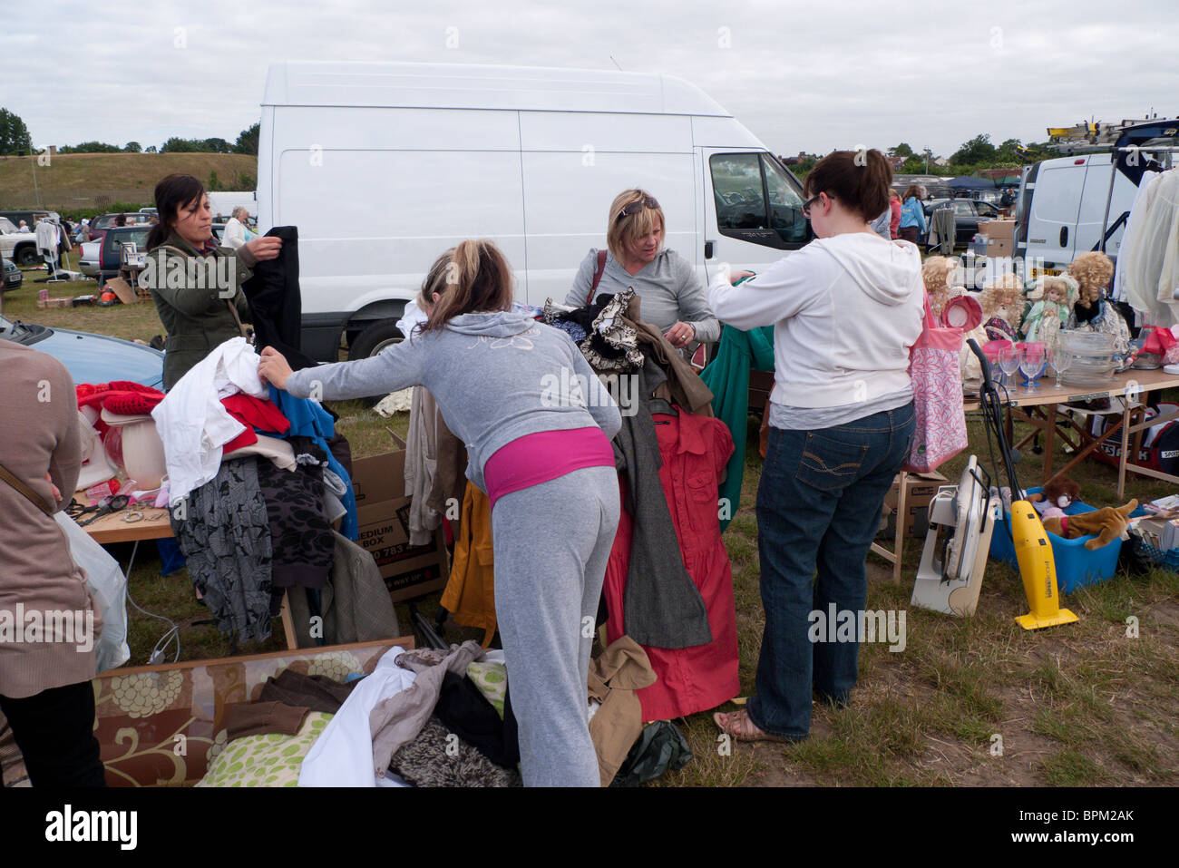 Chasse aux acheteurs pour négocier les vêtements à car boot sale à Apps ferme, Surrey, Angleterre Banque D'Images