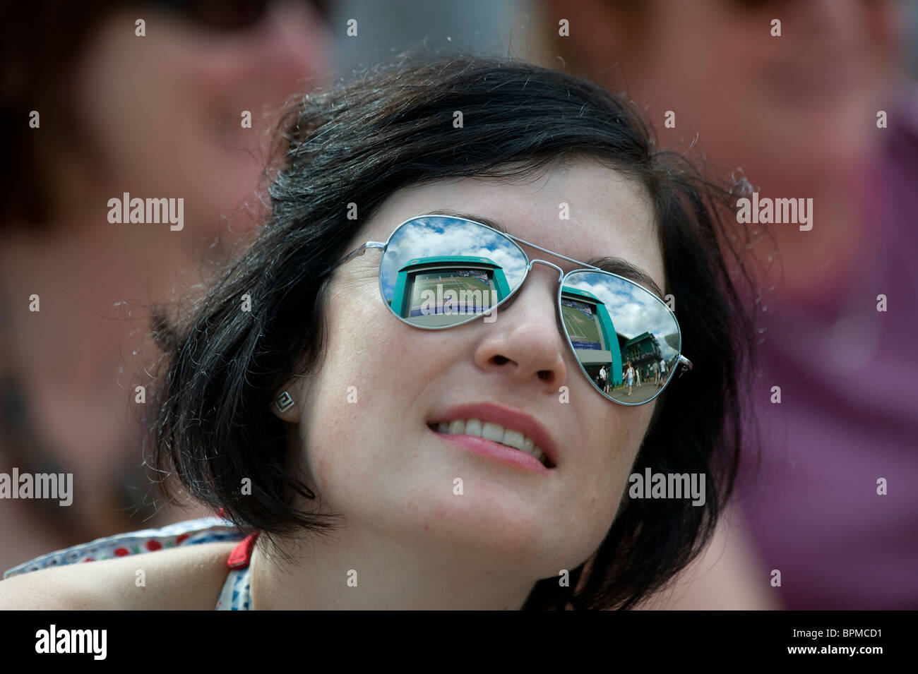 Une femme portant des lunettes de soleil montres jouer sur grand écran sur Henman Hill au cours de la Tennis de Wimbledon 2010 Banque D'Images