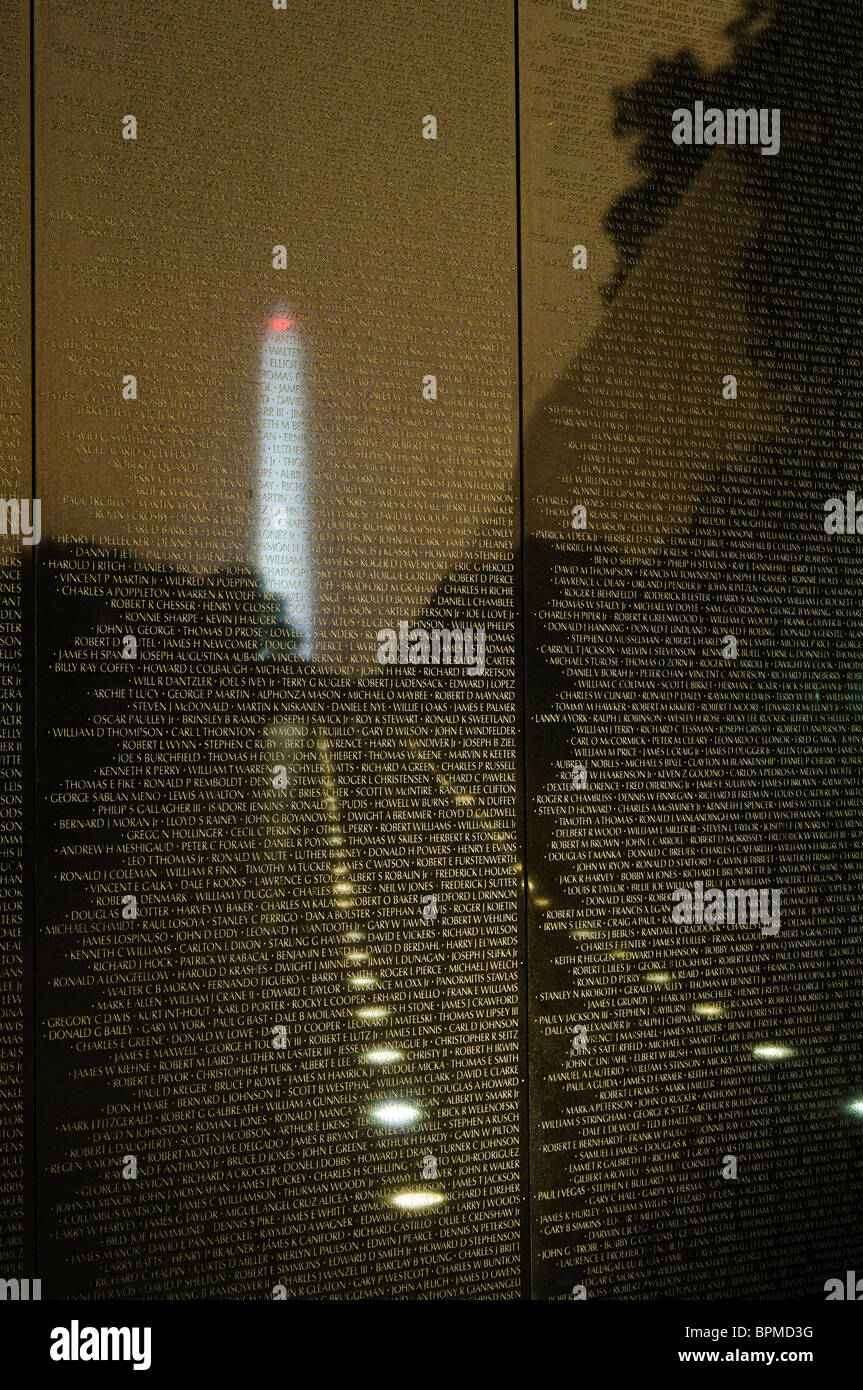 WASHINGTON DC, USA - photo de nuit de la Vietnam Veterans Memorial avec le Washington Monument réfléchi sur les noms de ceux qui ont été tués au Vietnam. Banque D'Images