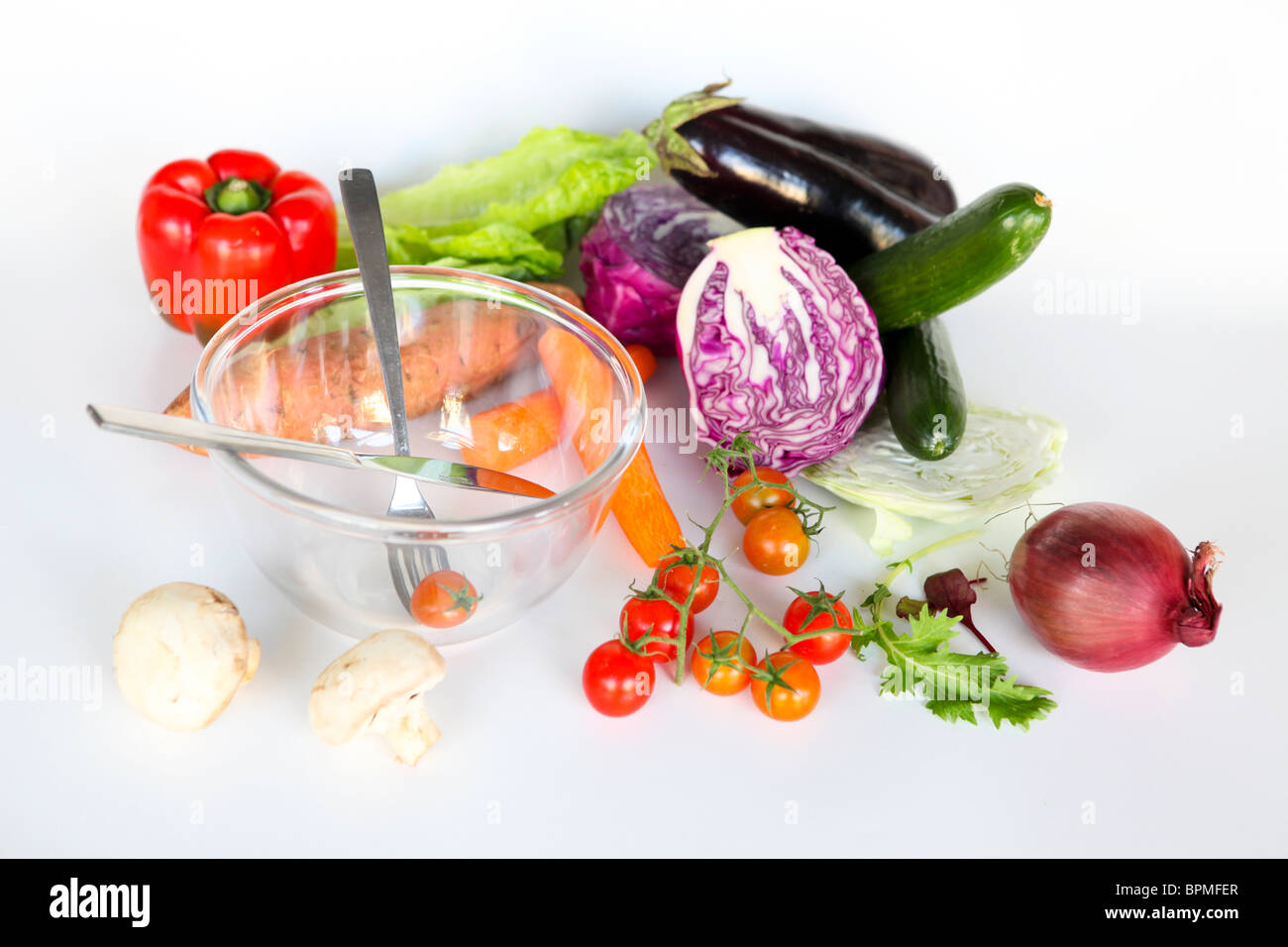 Des légumes frais et un bol à salade. Ensemble les ingrédients de la salade non coupée sur fond blanc Banque D'Images