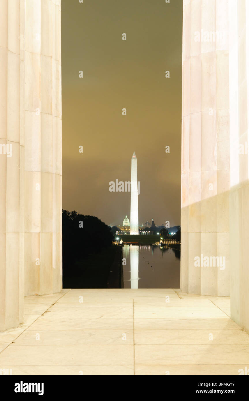 WASHINGTON DC, États-Unis — Une vue nocturne du Washington Monument vu depuis le Lincoln Memorial, avec le monument illuminé magnifiquement reflété sur les eaux calmes du bassin réfléchissant. Cette scène emblématique du National Mall capture la tranquillité et la grandeur des monuments de Washington DC la nuit. Banque D'Images