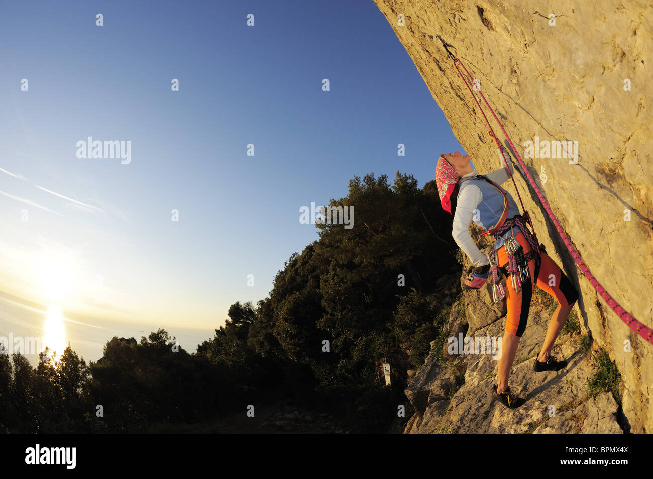 Woman climbing rock surplombant un visage au-dessus de la Méditerranée, le parc naturel de Porto Venere, parc national de Cinque Terre, l'UNES Banque D'Images