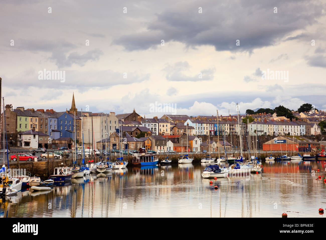 Bateaux amarrés à quai du port de pêche sur la rivière Seiont Afon avec maisons de ville au bord de la rivière au-delà. , Caernarfon Gwynedd, au nord du Pays de Galles, Royaume-Uni Banque D'Images