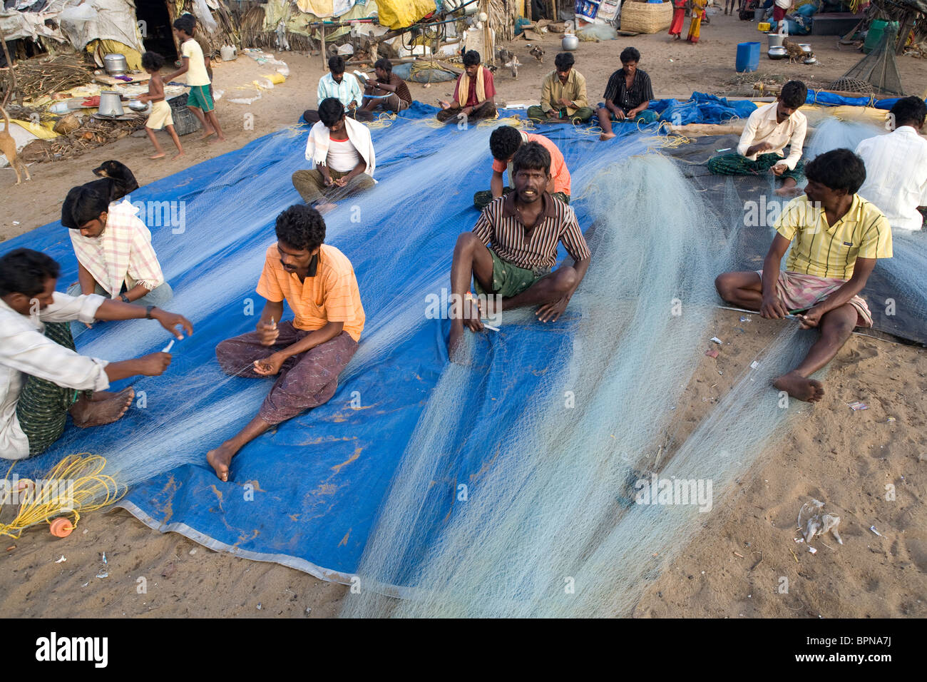 Les pêcheurs indiens sont en train de préparer les filets de pêche tôt le matin sur la plage du village de pêcheurs à Puri, Orissa, Inde. Banque D'Images