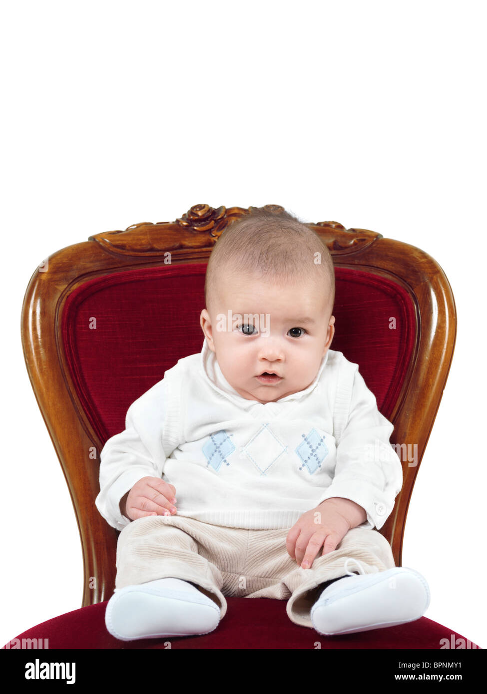 Photo humoristique d'un bébé de quatre mois garçon assis sur une chaise comme un roi sur un trône Banque D'Images
